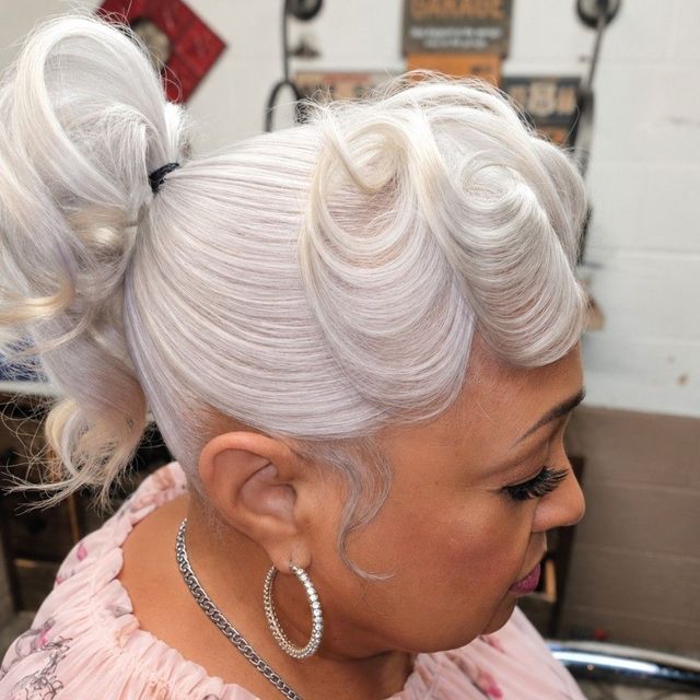 Platinum blonde pin-curl updo with a curled ponytail