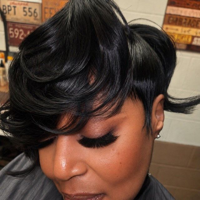Glossy black layered pixie with a long swept bang